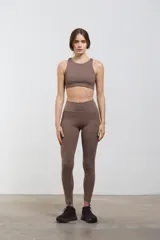 Calza deportiva larga de tiro alto, con bolsillos laterales integrados. Confeccionada en tejido elastizado de compresión media, con diseño liso y corte al tobillo.