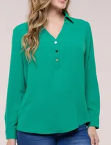 Blusa verde de calce holgado y caída fluida, confeccionada en tejido tipo crepé. Cuenta con cuello camisero con solapa, escote en V y cierre parcial al frente con tres botones metálicos. Las mangas son largas con puños abotonados.