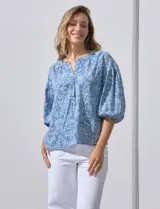 Blusa celeste con estampado floral blanco, escote en V y mangas 3/4 abullonadas con elástico, marca Zac & Rachel.