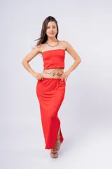 Pollera larga de color rojo, con diseño de corte recto y tajo lateral. Presenta una cintura elástica cómoda y un acabado satinado.