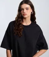 Remera oversize blanca de manga corta, con cuello redondo y diseño holgado, confeccionada en mezcla de algodón y poliéster.