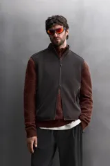 Chaleco negro de punto con interior de polar, cuello alto y cierre frontal con cremallera. Cuenta con bolsillos laterales con cierre. Zara Athleticz.