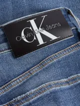 Jeans de calce slim, color azul, con pierna ajustada y tiro bajo.