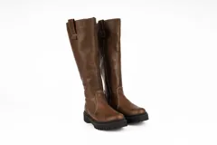 Bota de caña alta confeccionada en cuero nobuck color marrón, con suela track dentada y detalle de tirador en la parte superior de la caña.