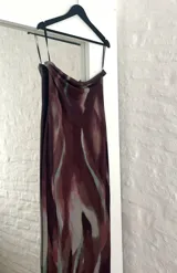 Vestido largo marrón con estampado abstracto en tonos celeste y blanco. Diseño strapless ajustado al cuerpo con abertura lateral en la falda.