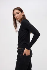 Remera de manga larga con cuello redondo, confeccionada en tejido rib con textura acanalada y calce ajustado al cuerpo.