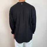 Camisa de manga larga con cuello mao, confeccionada en lino, con corte regular y cierre frontal de botones.