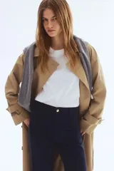 Pantalón acampanado de lona de algodón en color azul marino, con cintura de tiro alto, cierre de botón frontal y pliegues marcados en las piernas.