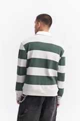 Polo de manga larga con diseño de rayas horizontales anchas en color marrón y crema. Presenta cuello camisero blanco con cartera de botones y estampado frontal con texto decorativo y logo de la marca.