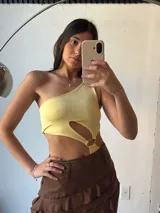 Body amarillo de un hombro con abertura en la cintura y aro metálico.