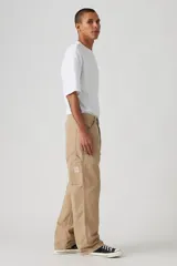 Pantalón de jean color beige, de corte recto y holgado, con bolsillos laterales y traseros.