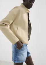 Short de denim azul de tiro medio, con diseño recto y clásico de cinco bolsillos, presillas para cinturón y cierre frontal con botón y cremallera.