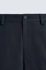 Bermuda de hombre color azul marino, de corte relajado (relaxed fit), confeccionada en tejido con textura. Presenta bolsillos frontales y bolsillos traseros de vivo, con cierre frontal de cremallera y botón.