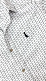 Camisa de manga larga a rayas verticales grises y blancas, con cuello clásico, cierre con botones y logo bordado en el pecho.