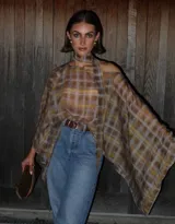 Blusa de silueta amplia y fluida con estampado a cuadros en tonos marrón y amarillo. Diseño asimétrico con mangas amplias y tira larga al cuello.