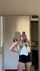 Top corto blanco y plateado con escote halter y espalda descubierta.