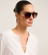 Blusa blanca de crepé con cuello en V, mangas largas y pliegues en los puños.