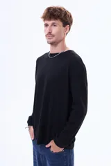 Buzo de manga larga en color negro, con cuello redondo y diseño de corte holgado.