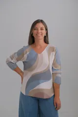 Sweater de punto con diseño de ondas abstractas en tonos beige, azul y rosado, con escote en V y mangas largas.