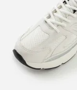 Championes de estilo jogging marca Satinato, confeccionados en poliuretano y poliéster. Presentan un diseño en color blanco con detalles en negro y gris, cierre por cordones, lengüeta y cuello acolchados, y una suela robusta.