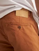 Bermuda color marrón de gabardina, corte chino, con bolsillos traseros tipo ojal con botón.