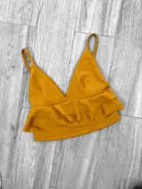 Top color rosa con breteles finos, escote en V y doble volado en el ruedo.