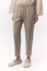 Pantalón estilo chino color beige con elástico en la cintura y cierre metálico en la pierna. Cuenta con bolsillos laterales con cierre invisible.