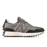 Championes New Balance modelo 327 para mujer, en tonos de gris oscuro y negro. Presentan una combinación de materiales como ante y malla, con el logo 'N' grande y asimétrico en textura de gamuza. La suela es de cuña ensanchada con relieve inspirado en zapatillas de trail.