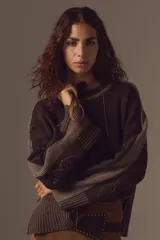 Sweater de tejido de punto color marrón chocolate, con mangas largas que presentan detalles bordados a mano y acabados en lurex. Posee puños acanalados y un diseño de corte holgado con cuello redondo.