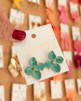 Aros colgantes con forma de flor color verde agua con detalles en dorado.