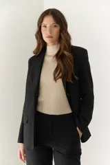 Blazer negro de poliéster, viscosa y spandex, con forro animal print, hombreras, botones frontales y en mangas.