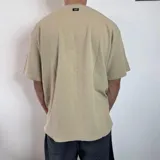 Remera de corte oversize color beige, con cuello redondo y estampa minimalista de un sol en el centro del pecho.