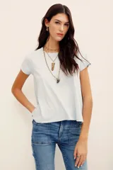 Remera básica de corte holgado, color negro, con mangas cortas y cuello redondo. Presenta un diseño con largo irregular y ruedo redondeado, confeccionada en algodón peruano con textura jaspeada.
