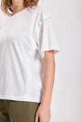 Remera blanca de algodón con cuello redondo y mangas cortas. Presenta un estampado de estrella en el frente.