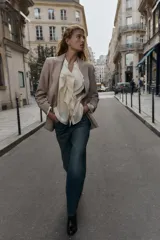 Blazer de corte sastrero confeccionado en tejido de lana con diseño de espiga. Presenta cuello con solapas, hombreras, cierre frontal con un botón y bolsillos delanteros con solapa.