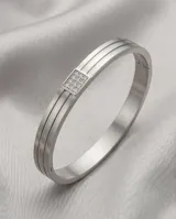 Esclava rígida de acero inoxidable con diseño de doble banda y detalle central cuadrado incrustado con circonias.