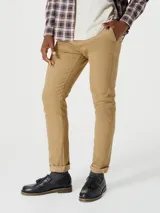 Pantalón tipo chino de corte slim, color beige, con cierre de botón y cremallera, y bolsillos laterales.