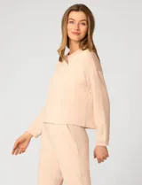 Buzo de punto color rosa, con cuello redondo y detalle de tejido crochet en el escote. Presenta mangas largas y un corte clásico con caída suave.