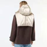 Plastrón con capucha de acabado metalizado en tono champán, diseñado para usar debajo de abrigos. Cuenta con cierre frontal y cordones ajustables en la capucha.