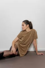 Vestido corto tipo remerón de lycra con acabado brillante color dorado. Presenta cuello redondo, mangas cortas y detalle de hombreras decoradas con tachas y cadenas metálicas.