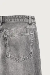 Jeans flare fit de denim de algodón en color celeste con lavado efecto desgastado. Presentan diseño de cinco bolsillos, tiro medio, cierre frontal con cremallera y botón, y bajo con acabado irregular.