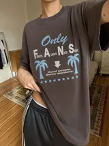 Remera oversize marrón con estampado gráfico frontal en tonos celestes y blancos con la leyenda "Only Fans", palmeras y estrellas.