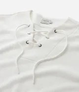 Bata masculina de manga larga en color blanco, confeccionada en tejido texturizado de algodón y poliéster. Presenta cuello en V con detalle de cordones cruzados y lazo ajustable.