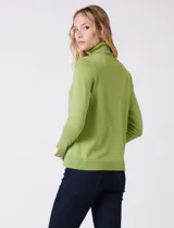 Polera de tejido fino, color rosado, con cuello alto, manga larga y detalle de tajo en los puños.