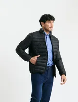 Campera acolchada tipo puffer en color gris, con cierre frontal, cuello alto y puños elásticos.