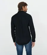 Camisa de manga larga confeccionada en terciopelo de algodón, con cuello clásico, cierre frontal con botones y bolsillo en el pecho.