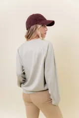 Buzo de manga larga color verde claro, con cuello redondo y calce relajado.