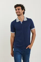 Remera azul con cuello y mangas con borde gris, corte clásico y bolsillo en el pecho.