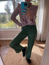 Pantalón slouchy de cuero ovino color verde inglés, corte mom fit con tiro semi alto y tajos inferiores.