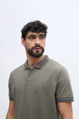 Chomba de piqué en color negro, de manga corta, con cuello y puños tejidos con líneas a contraste. Presenta cierre frontal parcial con botones y pequeño logo bordado en el pecho.